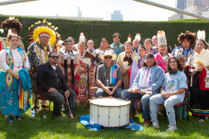 people pose around drum