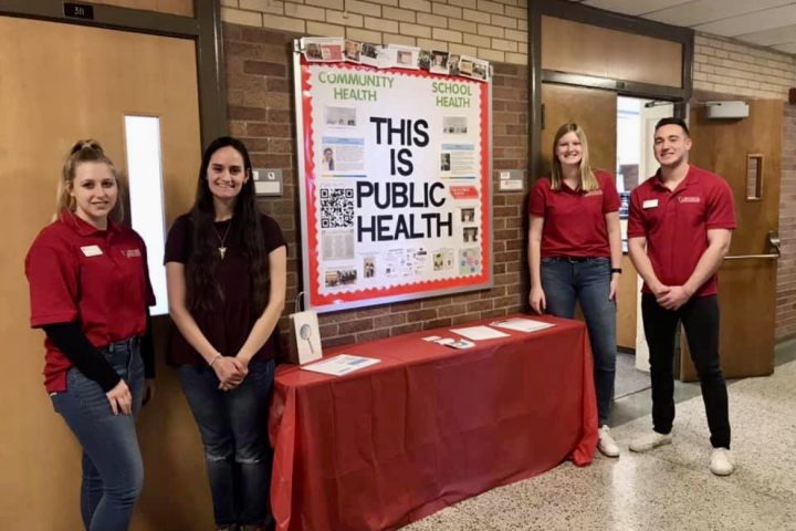 Students by table promoting public health.