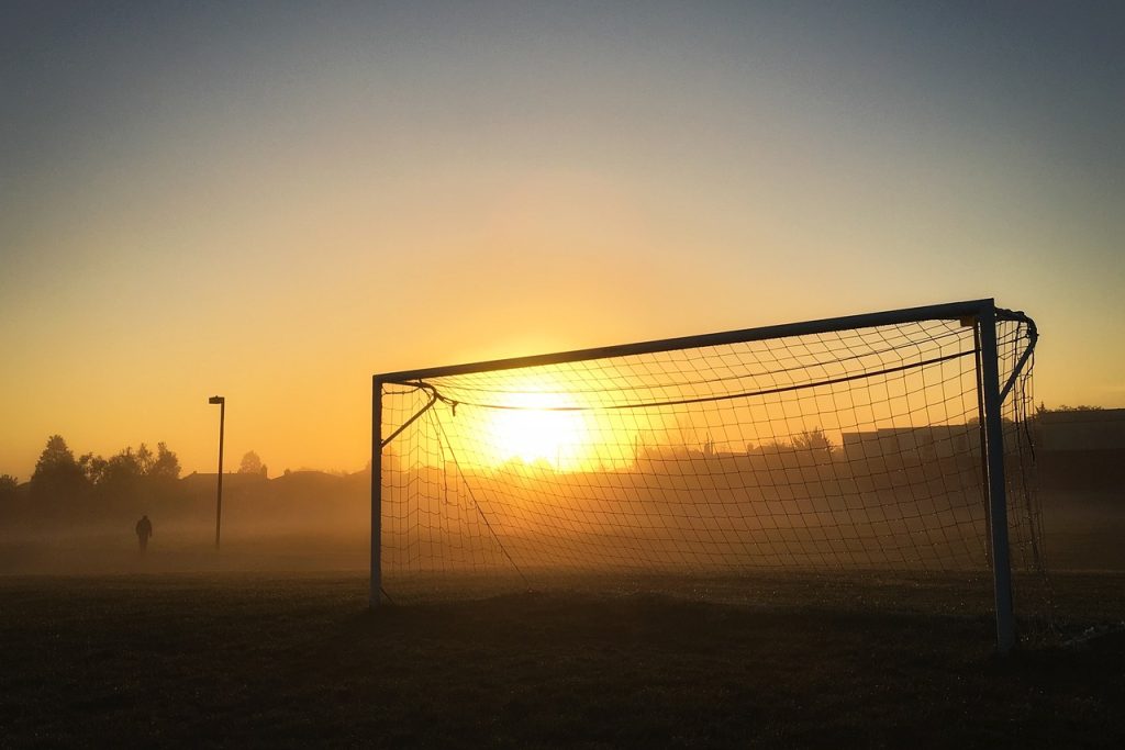 a soccer goal at sunset or sunrise