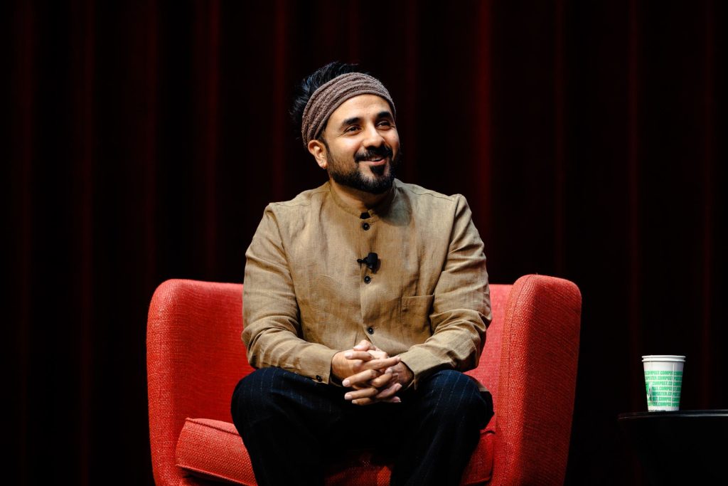 Vir Das sitting on a chair on stage in Brown Ballroom