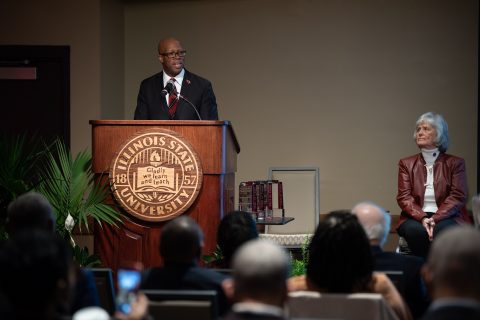 Dr. Levester Johnson at a lectern speaking to a crowd