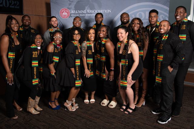 group of students with Umoja stoles pose for photo