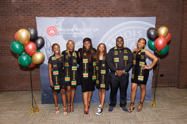Graduating students posing together at the Umoja Black graduation ceremony.