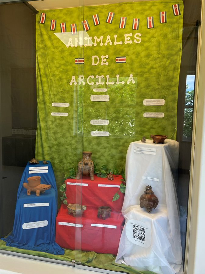 A glass case displaying Costa Rican animal clay sculptures 