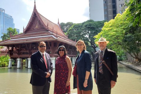 two men and two women standing in front of a Thai temple