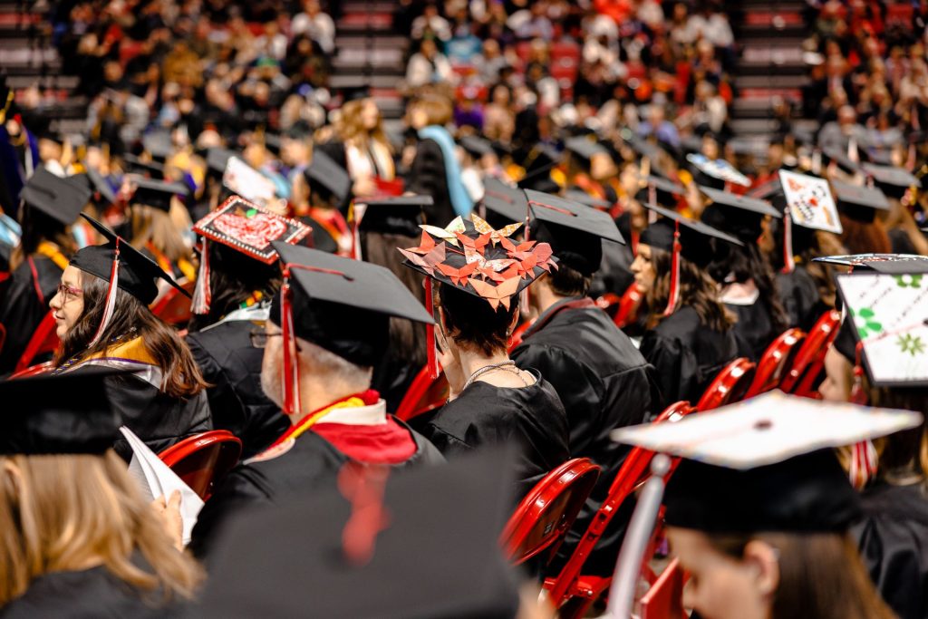 A wide-angle view of the back of caps and gowns during a commencement ceremony