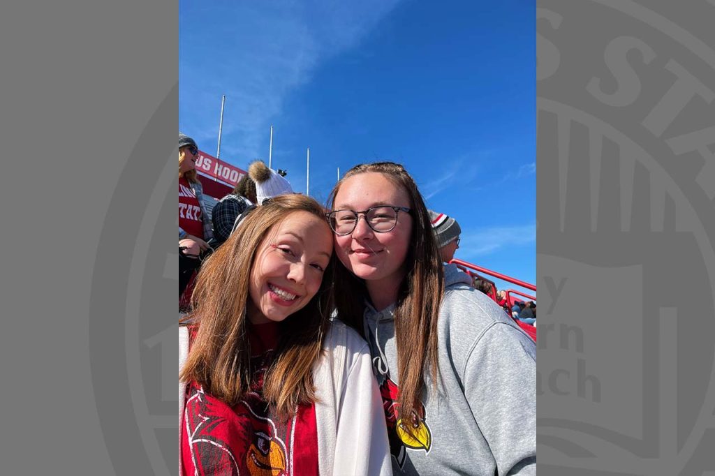 Two female students in the stands at an ISU football game