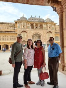 2 men and 2 women in front of historic palace in India