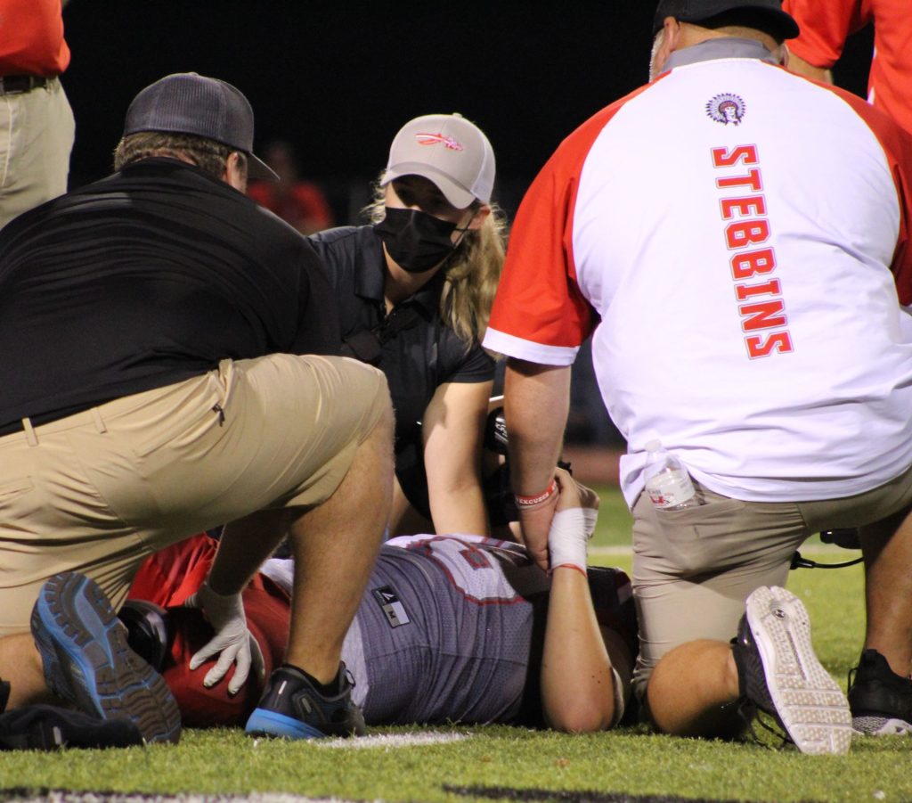 Athletic trainers providing care to an injured athlete