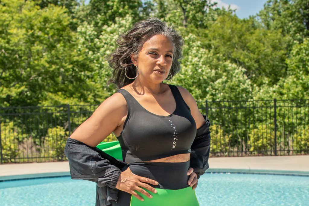 Head shot of Tracie Allen, standing in front of a pool with her hands on her hips.