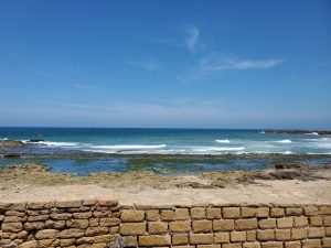 Ocean view behind tan brick wall