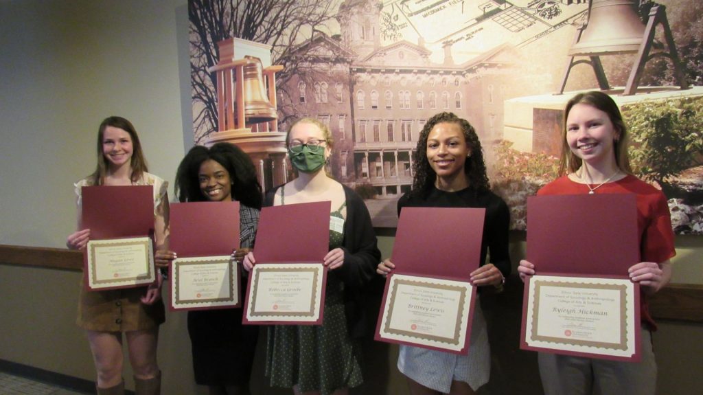 A group of young women holding up certificates
