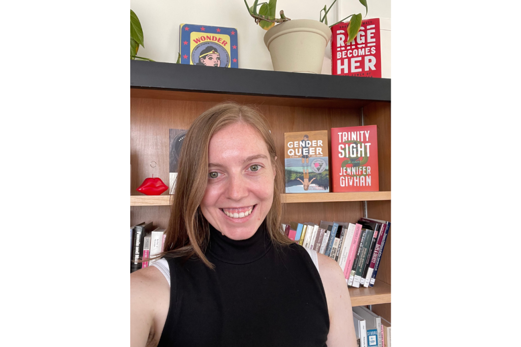Dr. Jacklyn Weier, WGSS Assistant Director, smiles in front of a bookshelf.
