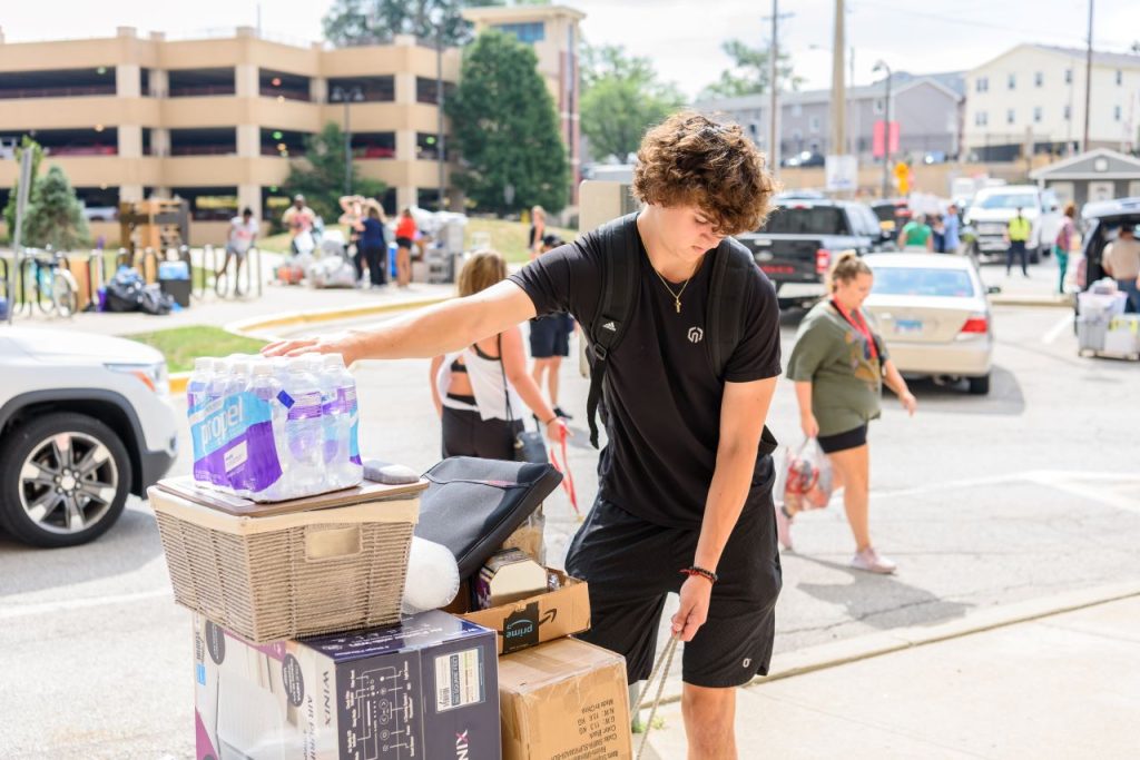 A student pulls a cart full of items during Move-In 2022.