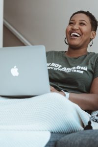 Person sitting with laptop and smiling