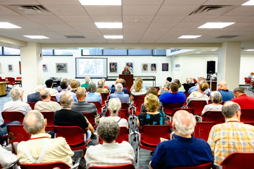 A speaker at Milner Library presents before a crowded audience