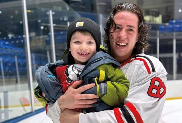 Redbird hockey player holding young fan