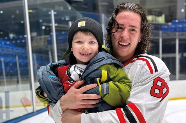 Redbird hockey player holding young fan