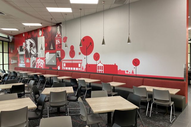 ISU branded wall mural behind booths, tables, and chairs featuring landmarks on ISU's campus