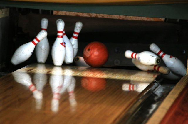 bowling ball knocking down pins
