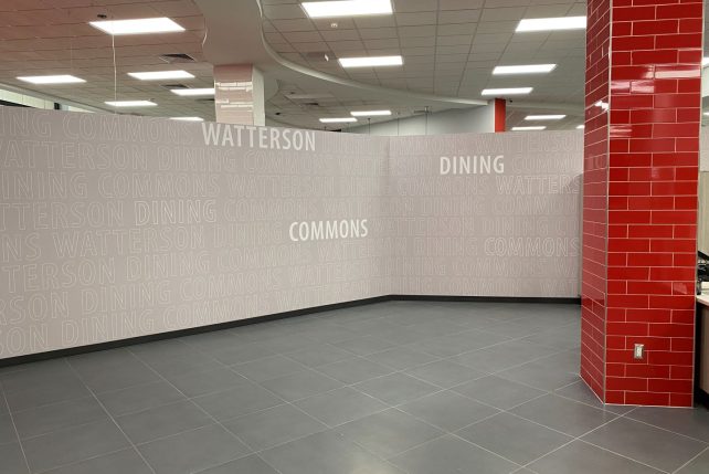 Entrance to Watterson Dining Commons with grey wall and Watterson Dining Commons written all over the wall.