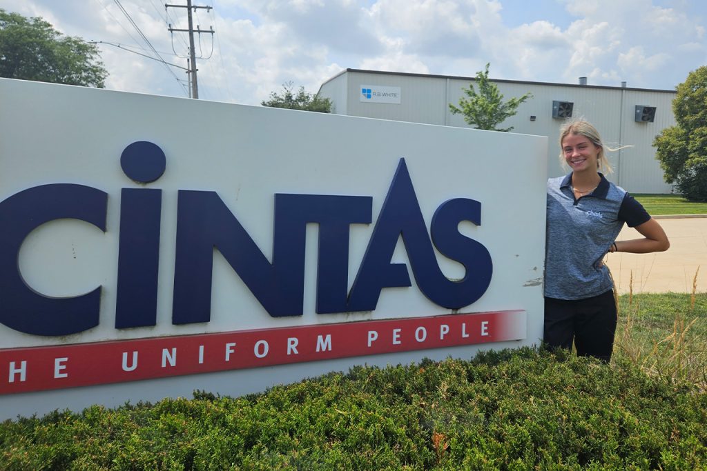 Illinois State student intern in front of Cintas sign