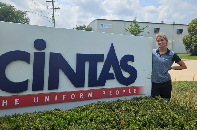 Illinois State student intern in front of Cintas sign