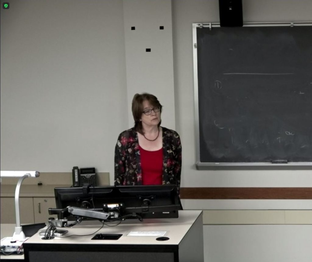 A woman giving a spoken presentation
