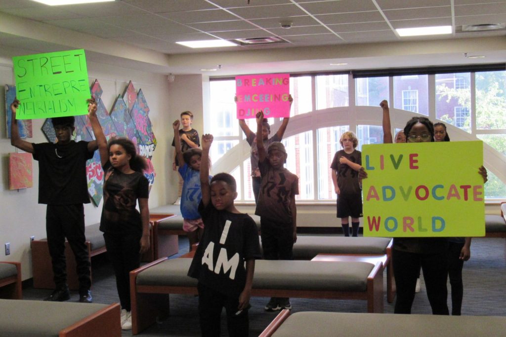 Children raising their fists and colorful signs in unison