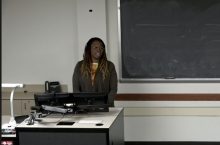 A woman standing in front of a computer leading a presentation