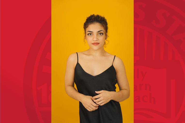 Laurie Hernandez in a black dress with a yellow background