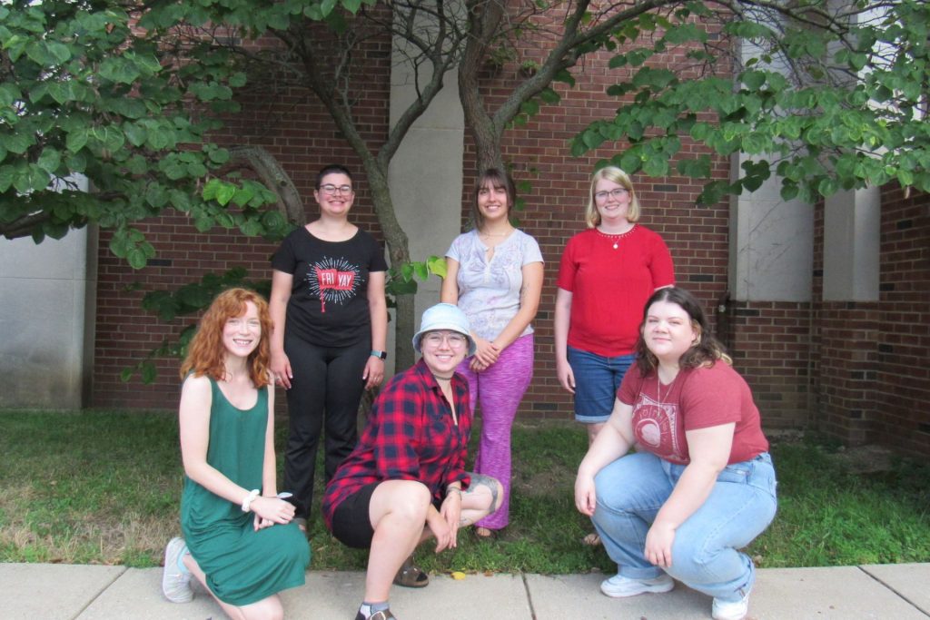 A group of students stand together in front of a building