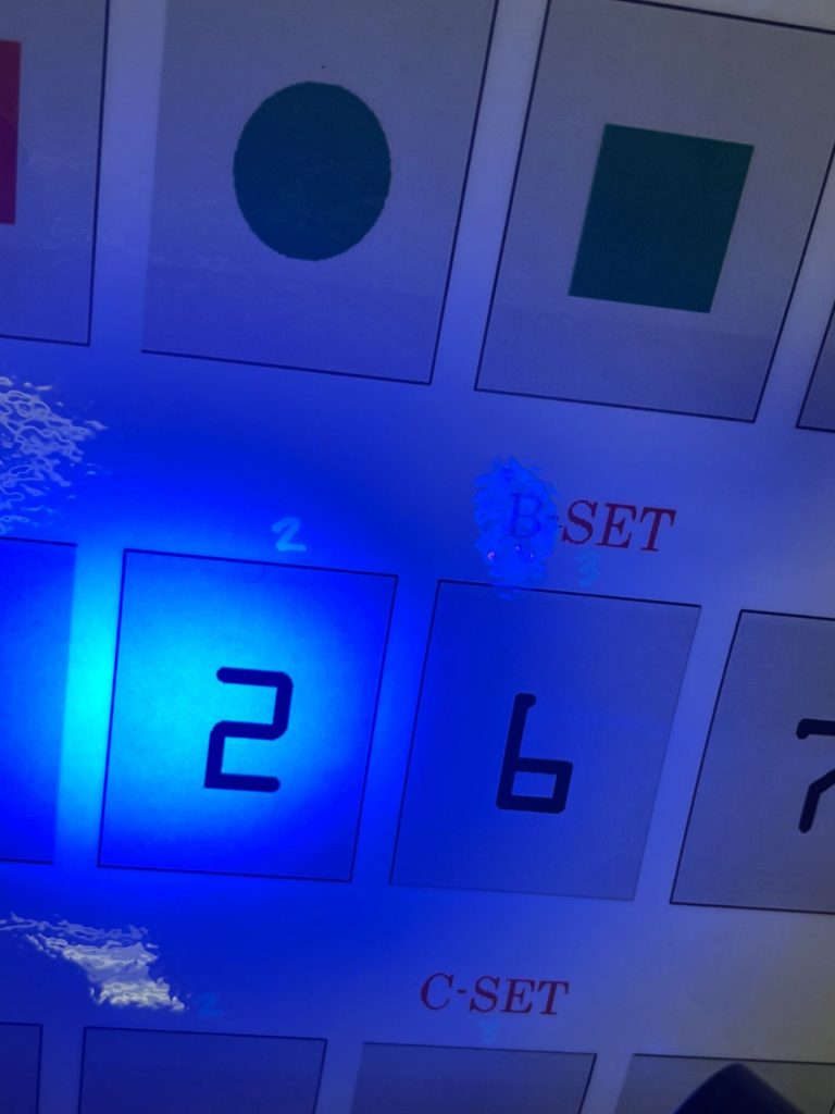 The number 2 is illuminated by a blue light on a game board.