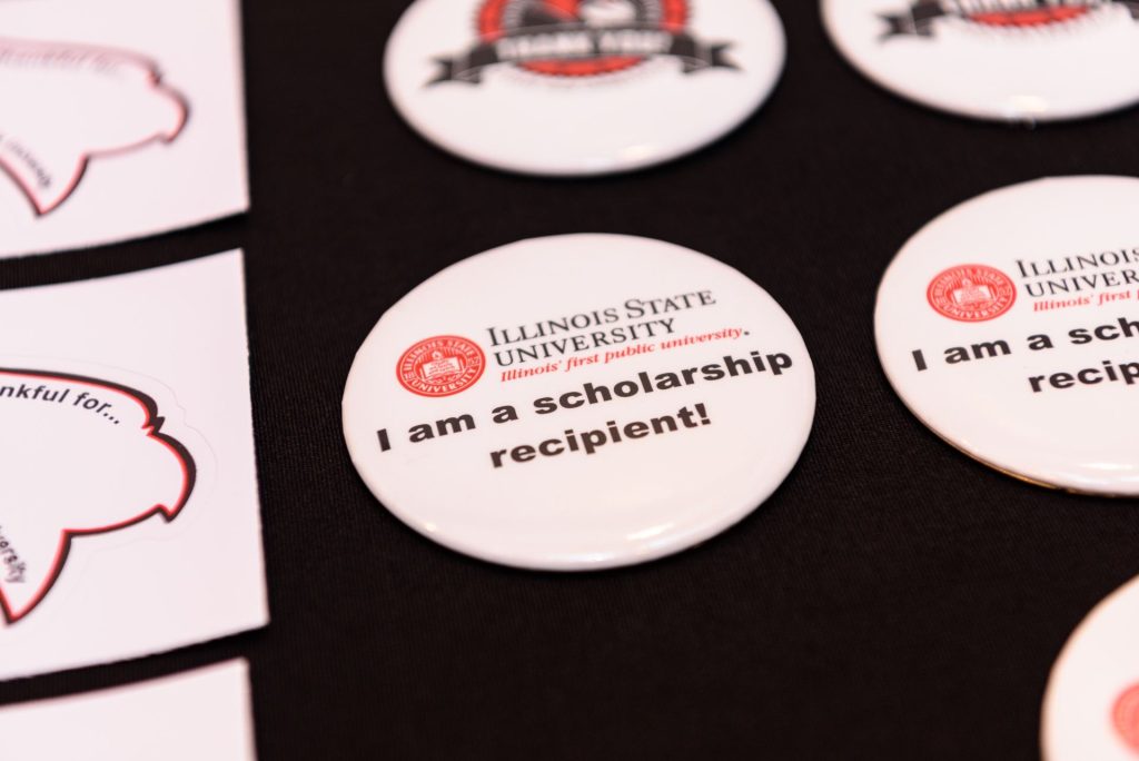 Pins for students to identify themselves as scholarship recipients on display on a table