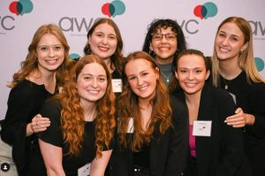 students in front of an AWC backdrop at an awards event