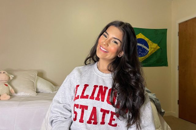 Student in a dorm wearing an Illinois State sweatshirt