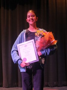 Lily Strode holds her award plaque and flowers