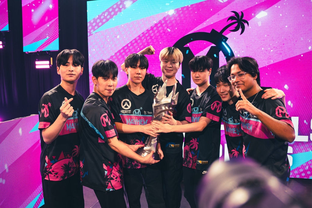 Esports teammates pose with trophy