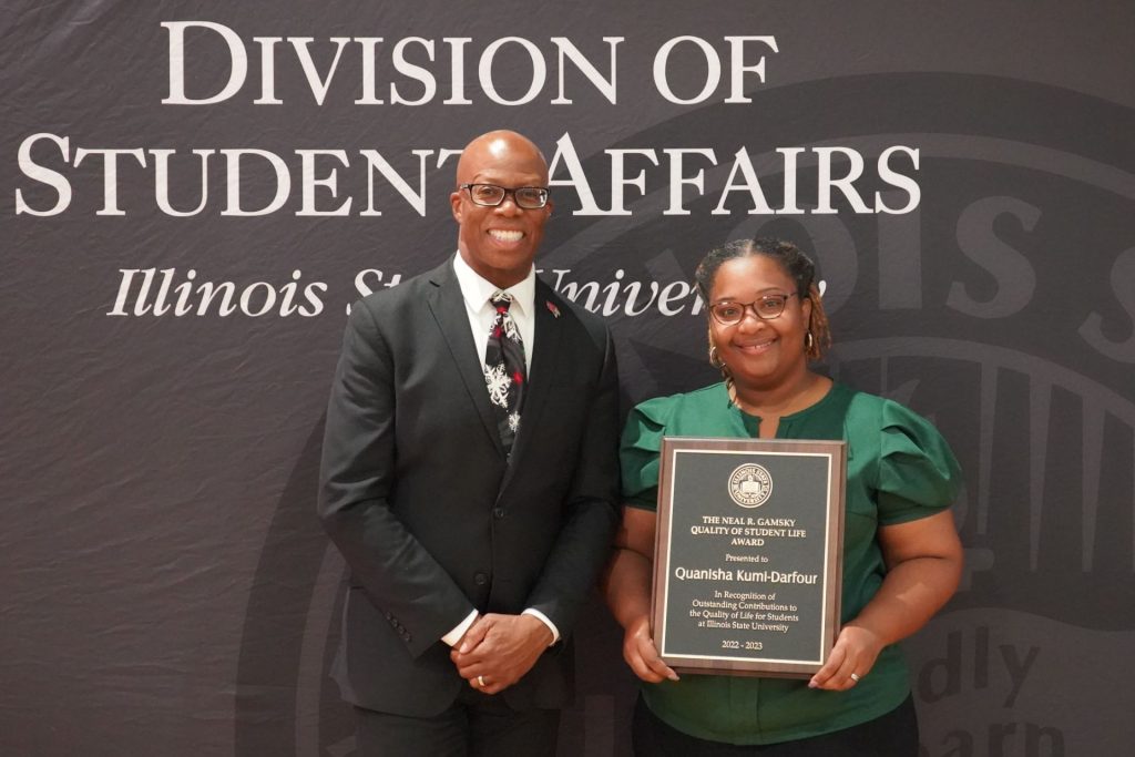 Quanisha Kumi-Darfour holds an award standing next to Levester Johnson, the vice president for student affairs