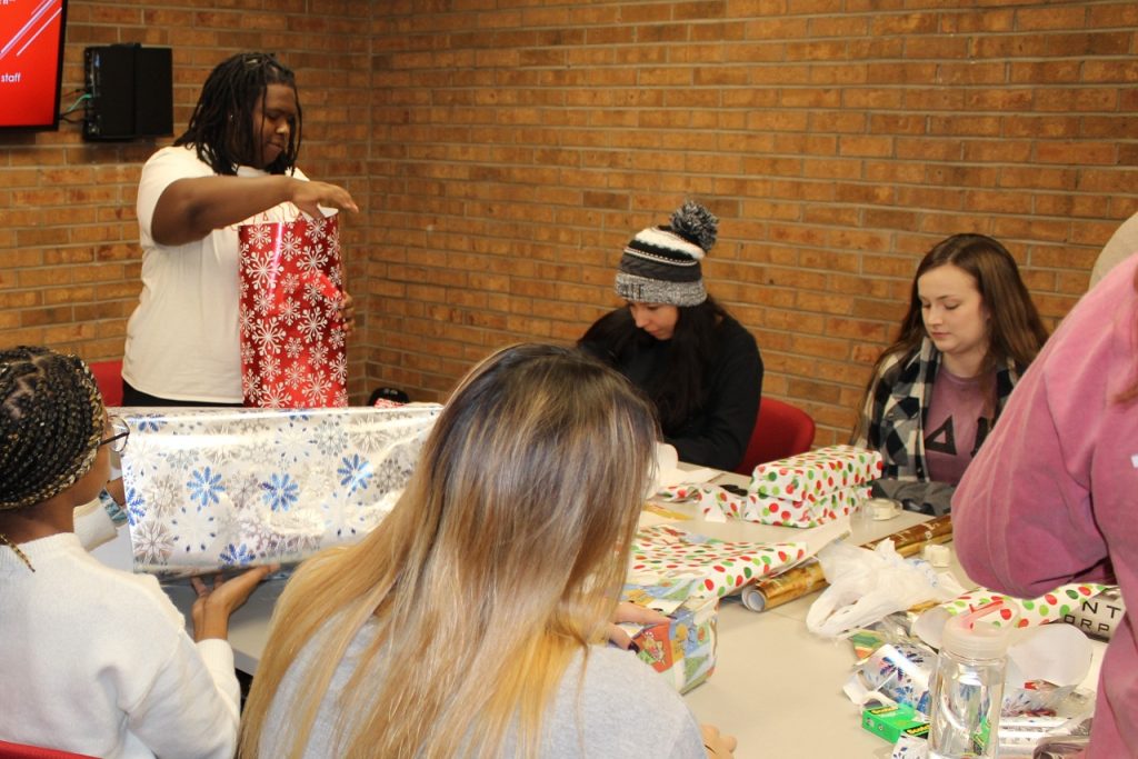 A group of students wrapping gifts at the Center for Civic Engagement during the 2018 edition of Holiday Helper.