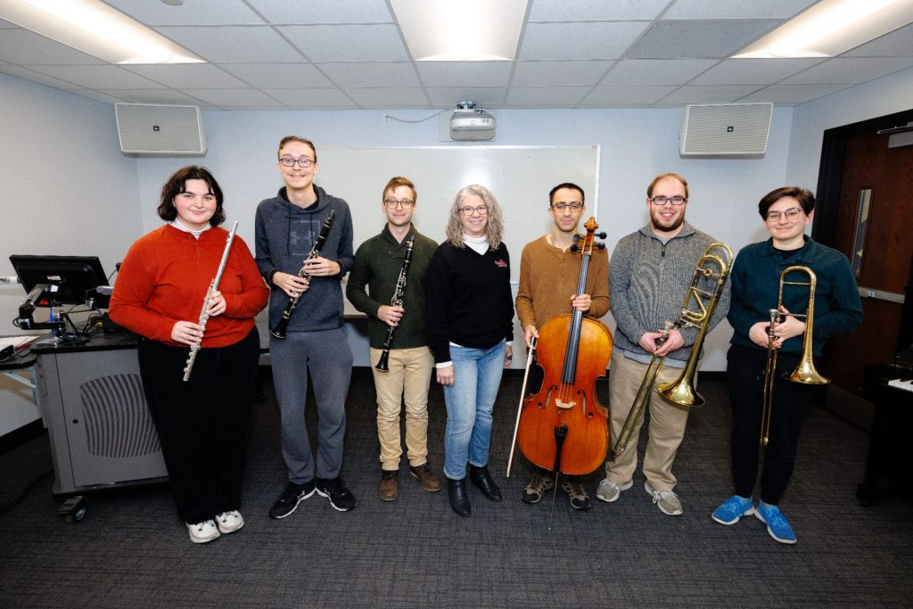 professor and her students pose with their instruments