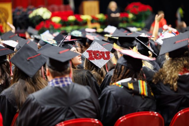 A focus shot on a graduate wearing an ISU branded graduation cap.