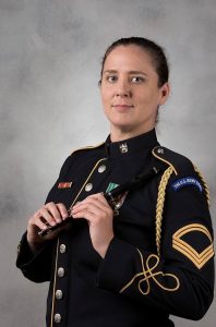 Headshot of alum Megan Lomonof dressed in her "Pershing's Own" uniform and holding a piccolo 