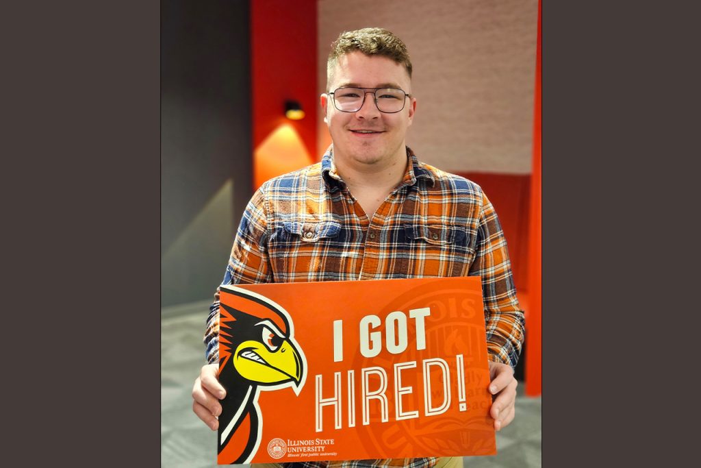 photo of student holding "I Got Hired" sign