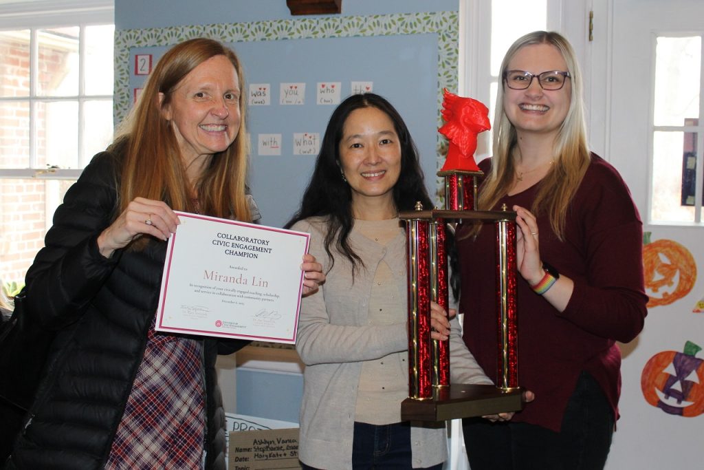Dr. Miranda Lin and two members of the CCE staff hold Dr. Lin's certificate and the Collaboratory Civic Engagement Champion trophy.