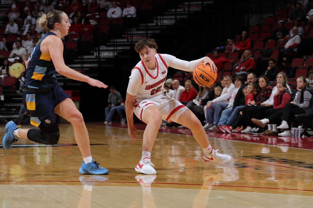 ISU women's basketball player protects the ball from a defender