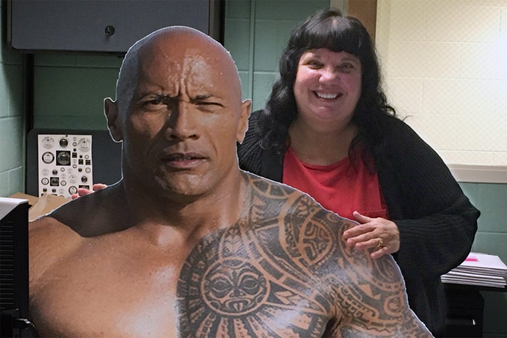 Annie holding a large cutout print of Dwayne "The Rock" Johnson