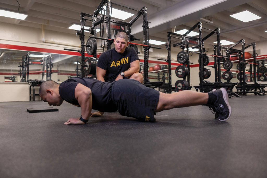 John Torres, CPT, U.S. Army and assistant professor, military science and Nathan Ji, cadet, ROTC, demonstrate proper push-up form.
