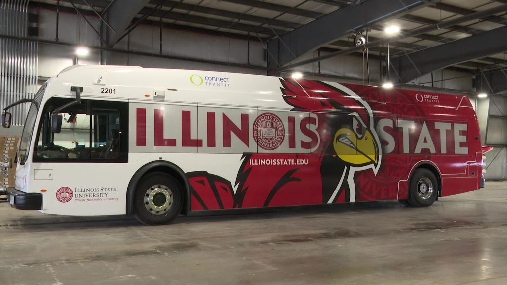 A public transit bus that says Illinois State on it with a large Reggie Redbird.