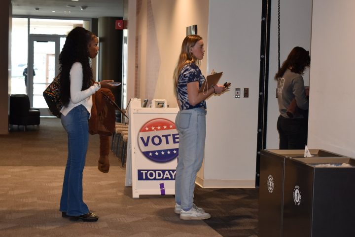 A group of people stands in line for a polling place in the Bone Student Center.
